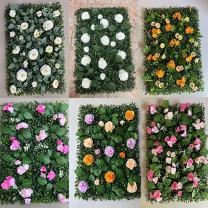 Variedad de paneles de plantas artificiales con flores decorativas y follaggio verde denso.