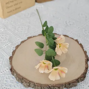 Detailansicht künstlicher Gesang-Blumen mit vier Köpfen auf einer Holzscheibe