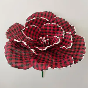 Détail en gros plan de fleur artificielle à carreaux rouges et noirs givrés de blanc.