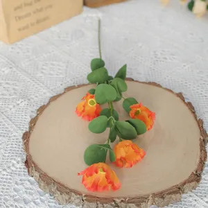Nahaufnahme einer vierköpfigen künstlichen Kosmosblume mit orange-roten Blüten
