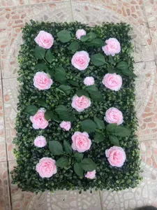 Detalle de panel de pared vegetal artificial con rosas rosas y hojas verdes exuberantes