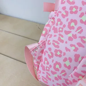 Close-up detail of the pink leopard print fabric and durable stitching on casual backpack