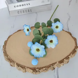 Vue détaillée de fleurs de cosmos bleu clair artificielles avec feuilles d'eucalyptus