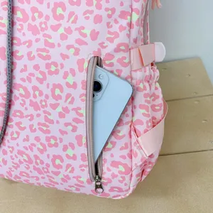 Detailed view of the side zipper pocket on a pink leopard print backpack with a smartphone