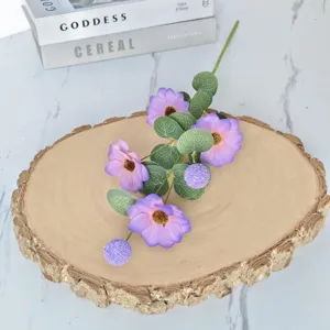 Gros plan de fleurs de cosmos violettes artificielles avec des feuilles d'eucalyptus vert