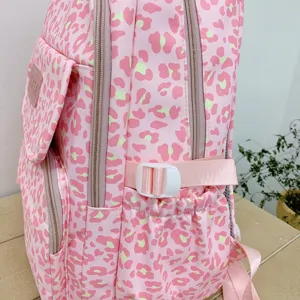 Close-up detail of a pink leopard print travel backpack showing side pocket and plastic buckle