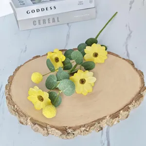 Vue détaillée d'une branche de marguerite jaune artificielle sur un socle en bois