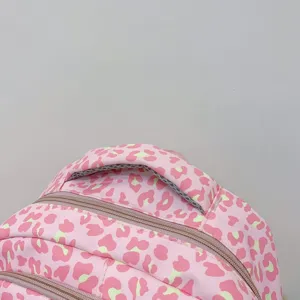 Macro detail showing the padded handle and durable zippers of the pink leopard backpack.