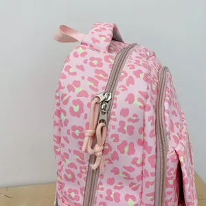 Detail of pink leopard print backpack with durable zipper and woven pulls.