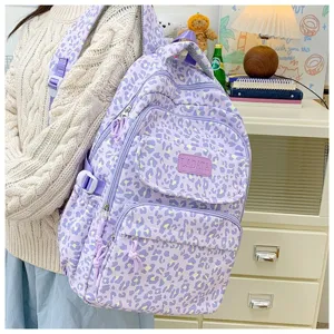 Lavender leopard print backpack worn by a student in a cozy indoor setting view