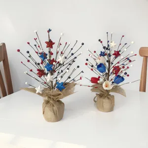 Detalle de ramas de bayas con estrellas rojas, blancas y azules en maceta de yute.