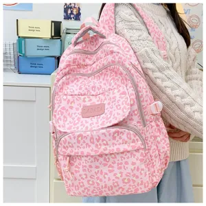 Detail view of pink leopard print backpack featuring multiple zipper compartments