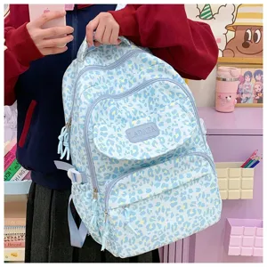 Side view of a light blue leopard print student backpack with multiple zip pockets