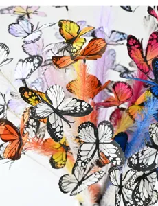 Detailansicht von bunten künstlichen Schmetterlings- und Feder-Schilfzweigen für DIY-Hochzeitsdeko.