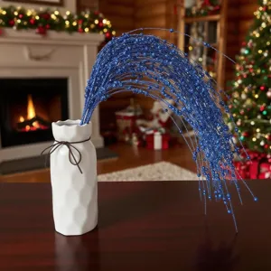 Ramo di bacche di Natale blu glitterato decorativo in un vaso bianco