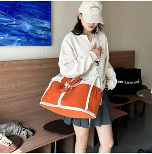 Large capacity orange canvas travel bag worn as a crossbody bag for sports and gym