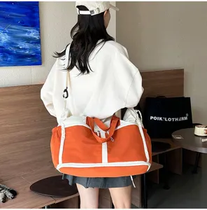 Large orange travel bag with wet-dry separation shown being carried by a model.