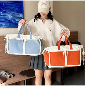 Large capacity travel duffel bags in blue and orange shown by a model in an indoor setting
