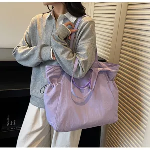 Large lavender waterproof travel tote bag worn by a model in a stylish setting