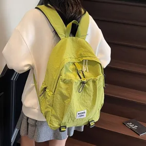 Student wearing a white sweater carrying a green large capacity fashion backpack