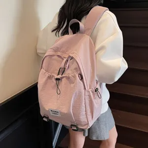 Close-up detail of a stylish pink large capacity student backpack worn on stairs