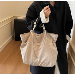 Detail view of large beige waterproof shoulder bag for travel and commute
