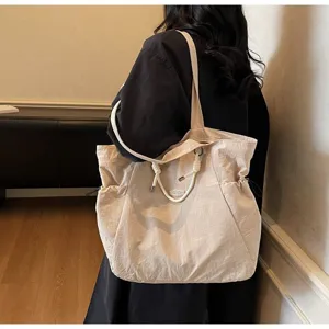 Large beige waterproof nylon shoulder bag for travel and daily commute on model