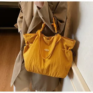 Large yellow waterproof tote bag for travel and commuting shown in a lifestyle setting