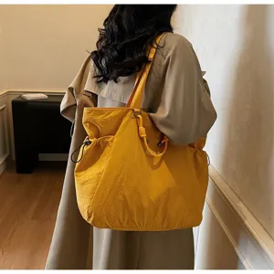 Large yellow waterproof nylon shoulder bag for travel and daily commute detail shot view.