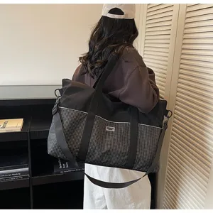 Grand sac de voyage et de fitness avec un design à carreaux élégant, idéal pour le sport.