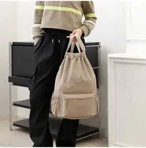 Vue détaillée d'un sac à dos de sport beige léger à cordon avec poche avant et rangement latéral
