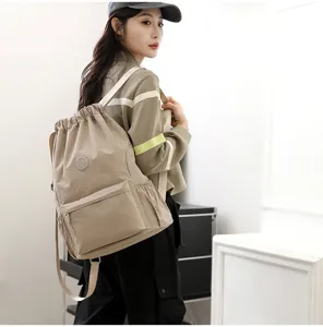 Mannequin portant un sac à dos à cordon kaki avec poche zippée dans un décor de studio