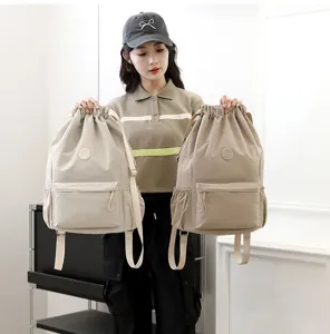 Femme tenant deux sacs à dos de sport légers à cordon en beige et kaki pour les détails