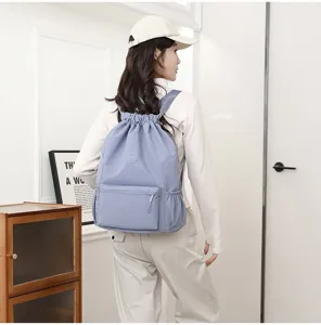 Photo lifestyle d'une femme portant un sac à dos de sport bleu clair léger à cordon