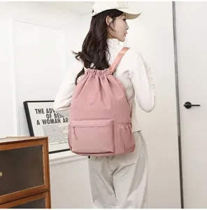 Vue de dos d'une femme portant un sac à dos de sport rose léger avec cordon de serrage