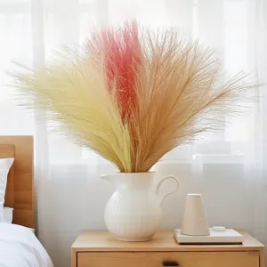 Nahaufnahme von künstlichem Pampasgras in einer weißen Keramikvase auf Holztisch.