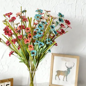 Ramo de flores de margaritas artificiales coloridas en jarrón de vidrio para decoración.