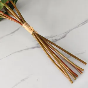 Close-up detailweergave van kunstmatige rozenboeketstelen gebonden met natuurlijk raffia.