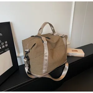 Close-up of large capacity checkered travel bag in a stylish lifestyle interior setting.