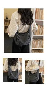 Detail view of a vintage large-capacity hobo bag worn by a model in a library setting.