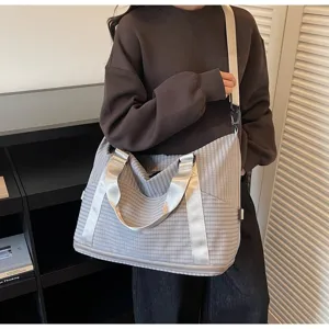 Large capacity grey checkered travel bag shown worn on shoulder for short trips