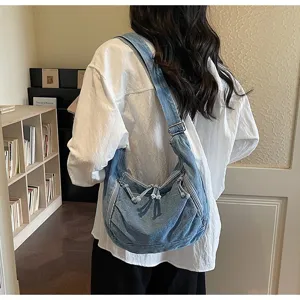 Vintage large capacity denim dumpling crossbody bag for women in a lifestyle indoor setting