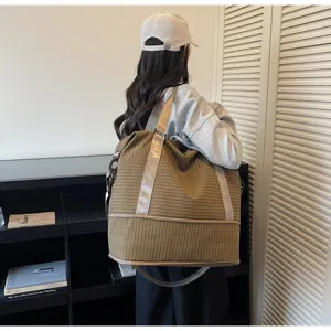 Large capacity checkered travel bag for women carried by a model from a back view