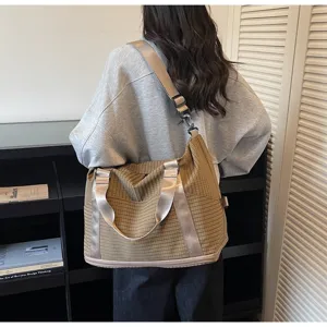 Large capacity brown plaid travel bag with crossbody strap shown on model for weekend trips