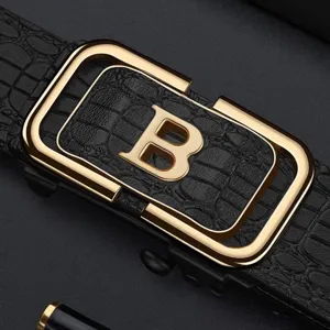 Macro detail showing gold letter B buckle on black men's crocodile embossed leather belt
