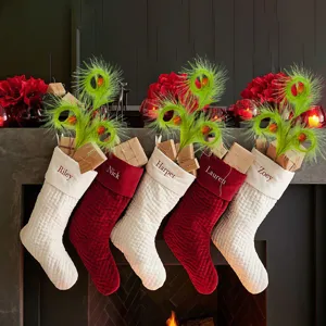 Detailed view of quilted Christmas stockings with personalized name embroidery hanging on mantel