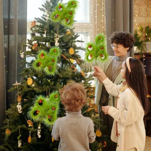 Family decorating a Christmas tree with whimsical green feather and red ball ornaments.