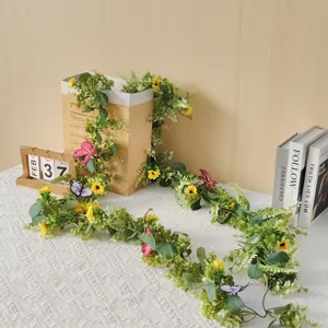 Detailed view of artificial sunflower vine garland with green leaves and butterfly decor.