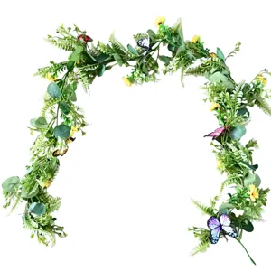 Artificial greenery garland detail with small yellow flowers and colorful butterflies.