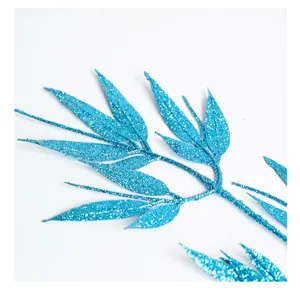 Blue glitter bamboo leaf branch detail, sparkling artificial plant for holiday decor.